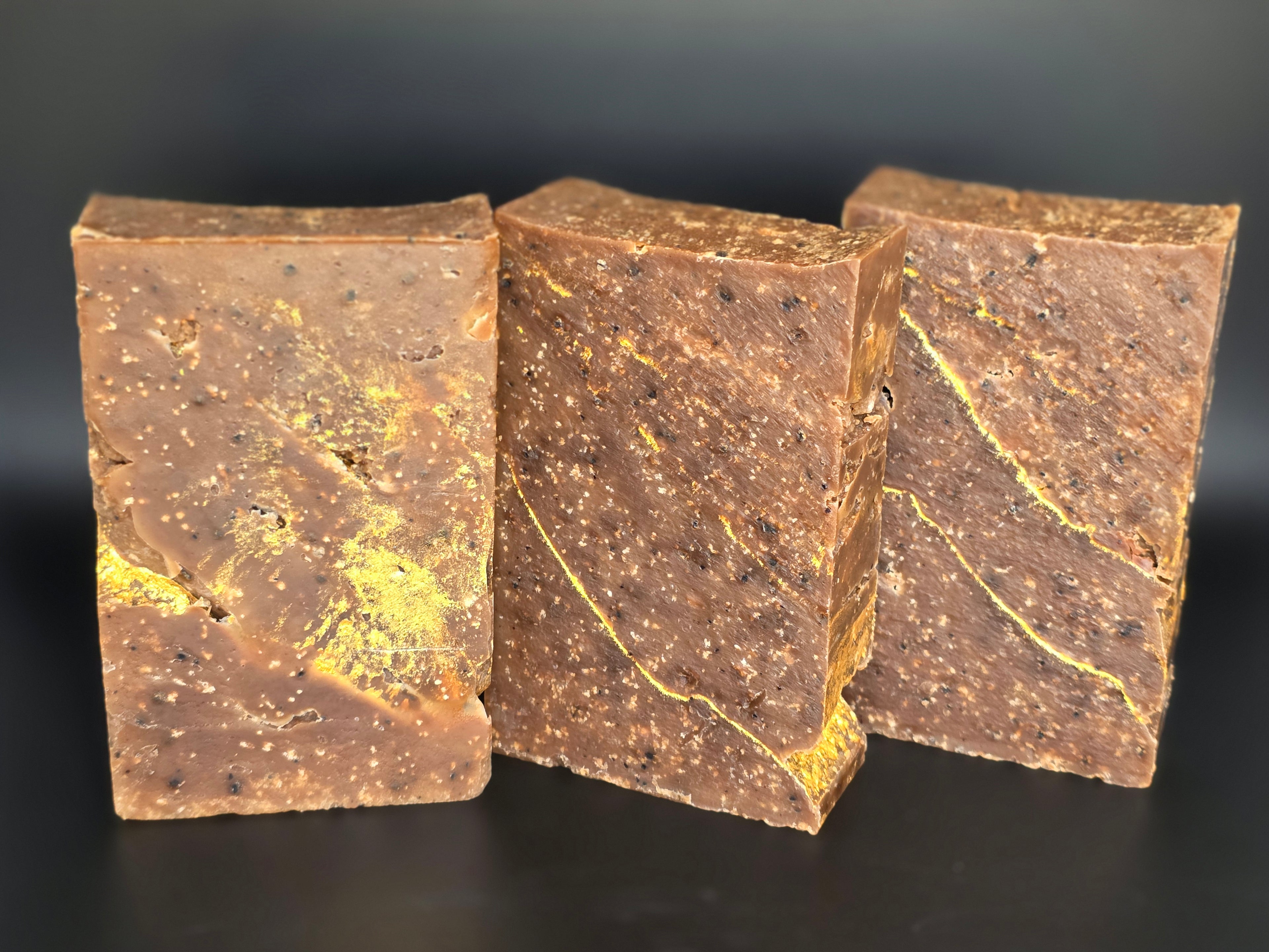Gilded Espresso is a handcrafted cold process soap made in small batches with rich espresso and dark chocolate notes, natural coffee elements, and a gold-veined design.