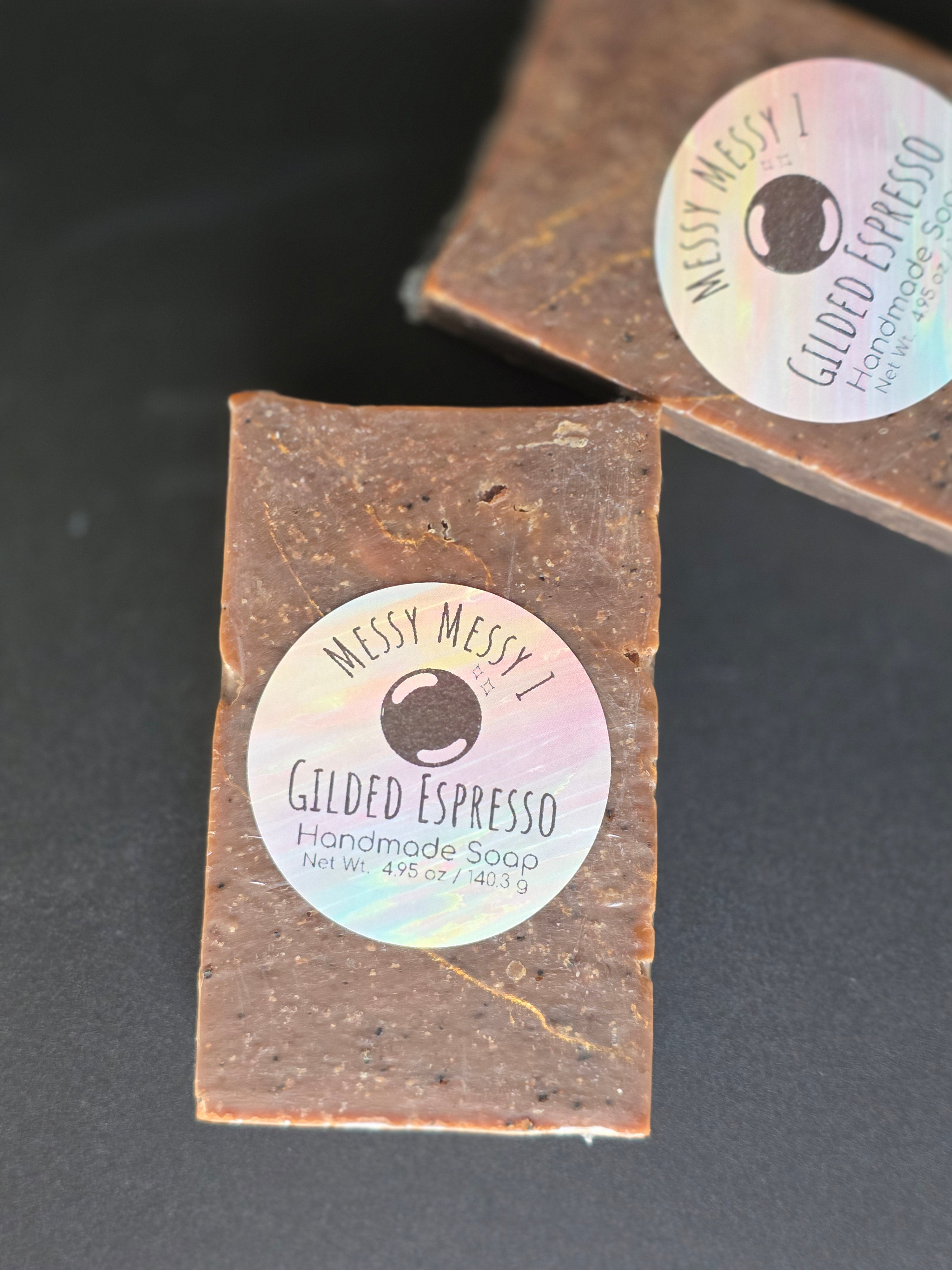 Gilded Espresso is a handcrafted cold process soap made in small batches with rich espresso and dark chocolate notes, natural coffee elements, and a gold-veined design.