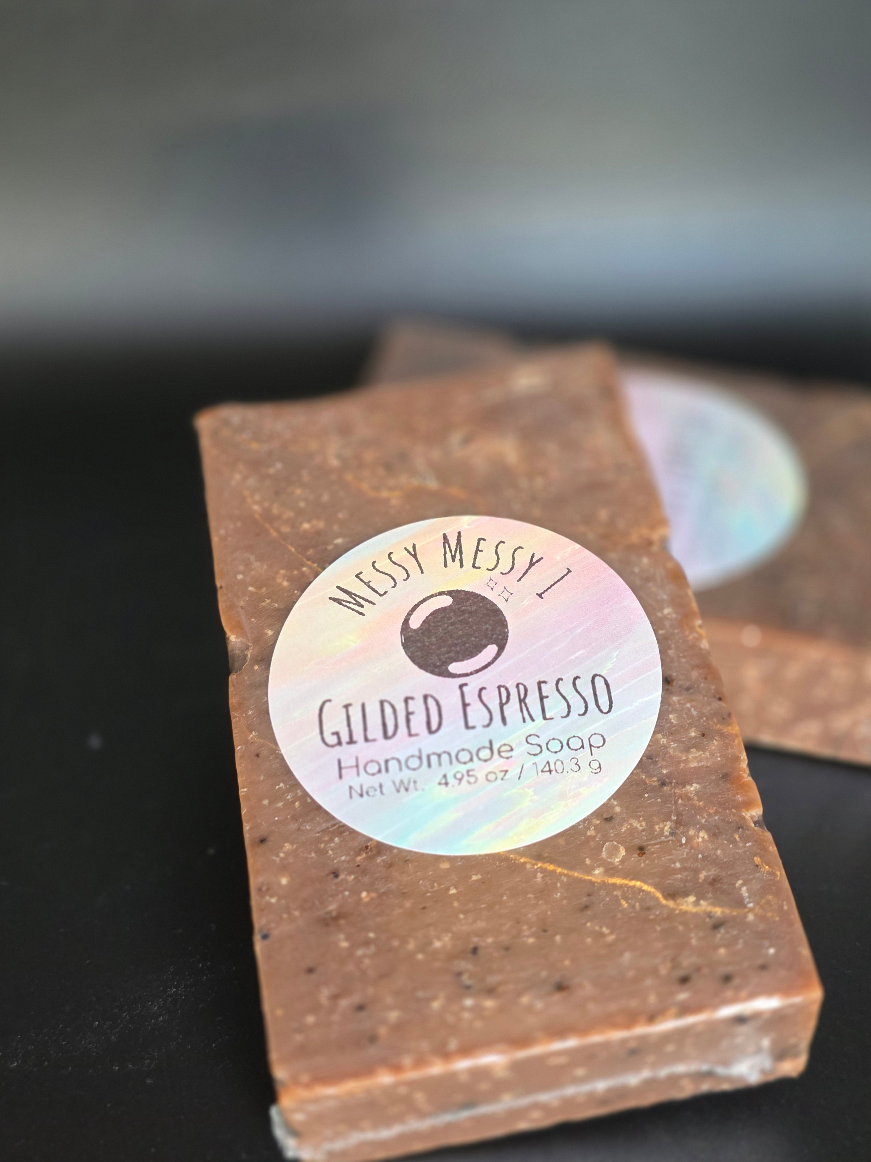 Gilded Espresso is a handcrafted cold process soap made in small batches with rich espresso and dark chocolate notes, natural coffee elements, and a gold-veined design.