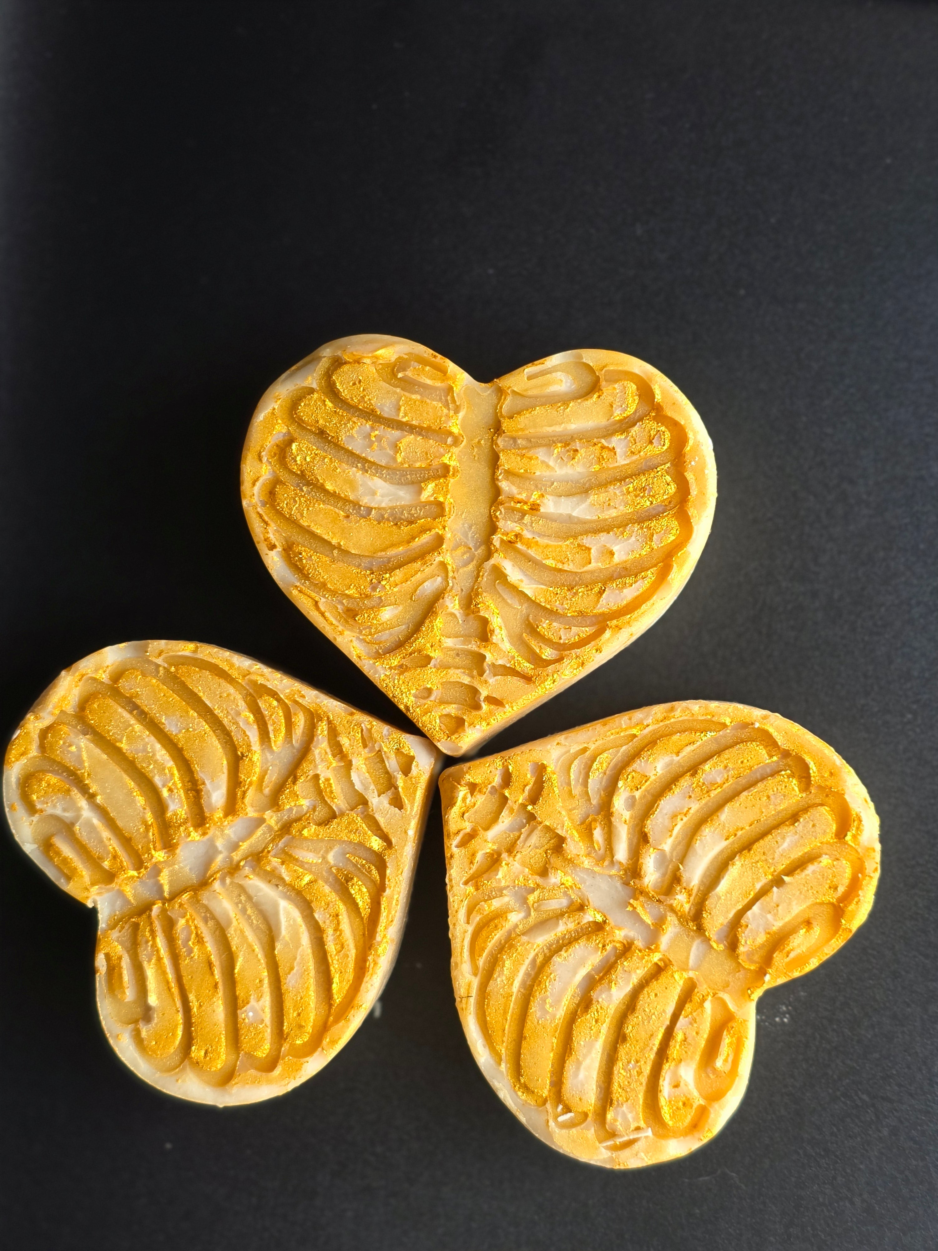Golden Remains is a handcrafted cold process soap made in small batches from leftover Spring Solstice batter, poured into a detailed heart mold with a skeletal design and finished with gold mica. Lmited soap
